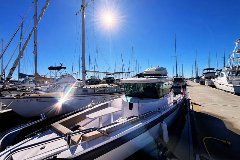 2022 Axopar 28 AFT CABIN boat docked in sunny marina with sailboats.