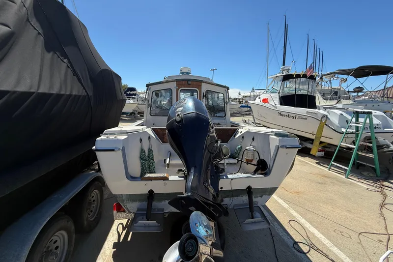 1996 C-Dory 22 boat with outboard motor in a marina setting.