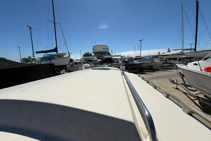 1996 C-Dory 22 boat in marina, surrounded by various vessels under clear blue sky.