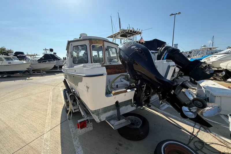 1996 C-Dory 22 boat with outboard motor on trailer in marina.