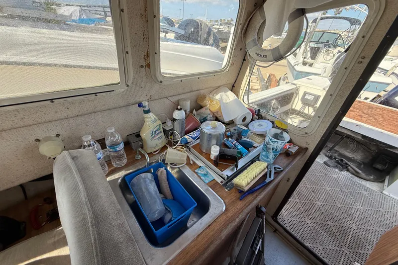Interior of a 1996 C-Dory 22 boat with cleaning supplies and tools on a counter.