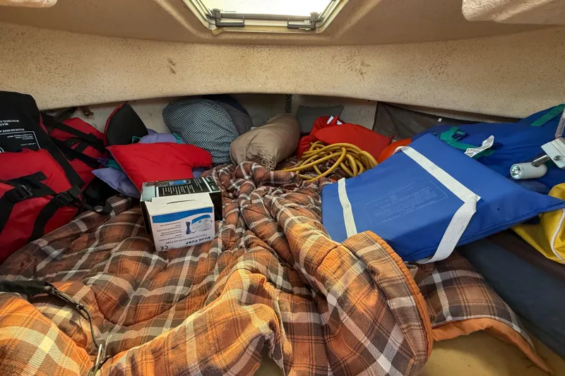 Interior of a 1996 C-Dory 22 boat with blankets and safety gear.