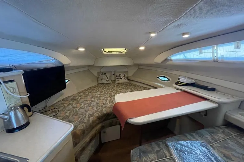 2000 Bayliner 2655 Ciera Sunbridge cabin interior with seating, table, and kitchenette.