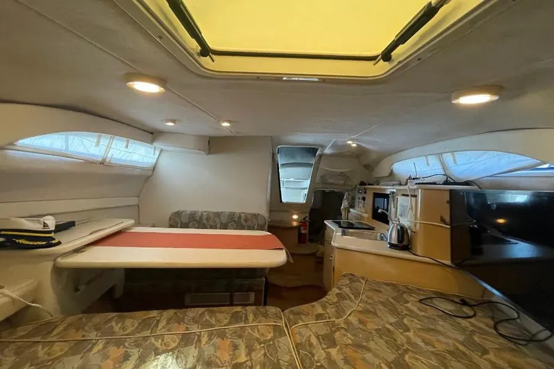 Interior of 2000 Bayliner 2655 Ciera Sunbridge, featuring dining area and kitchenette.