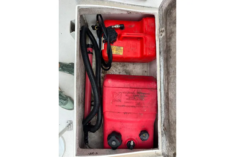Red fuel containers in storage compartment of 1979 Islander Peterson 40 sailboat.