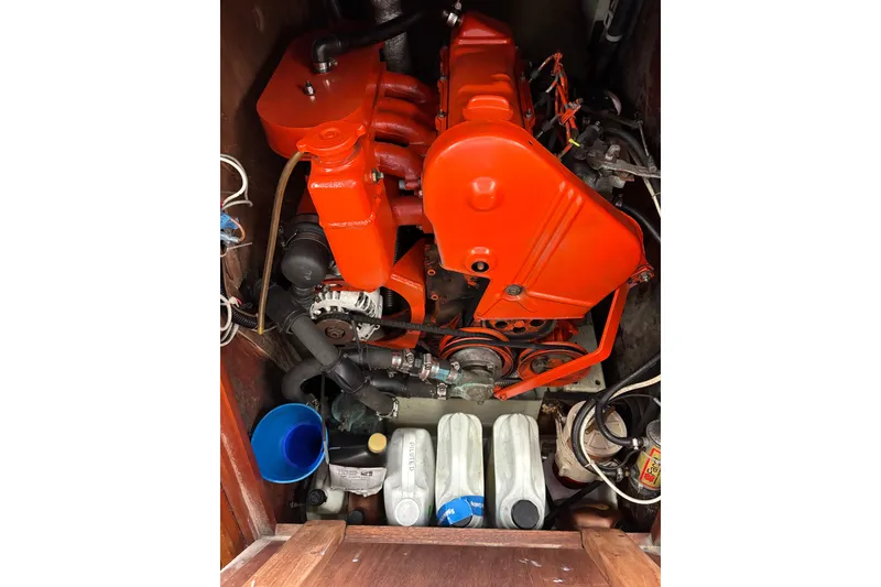Engine compartment of a 1979 Islander Peterson 40 sailboat with bright orange components.