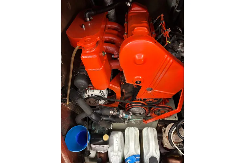Engine compartment of a 1979 Islander Peterson 40 sailboat, featuring a bright red engine.