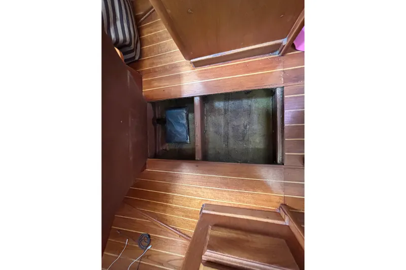 Interior view of 1979 Islander Peterson 40 sailboat with wooden flooring and open hatch.