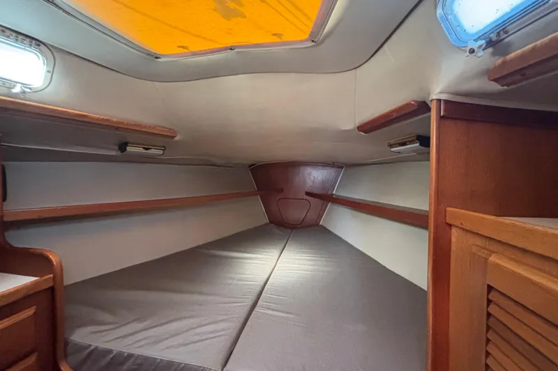 Interior cabin of 1979 Islander Peterson 40 sailboat, featuring wooden accents and cozy sleeping area.