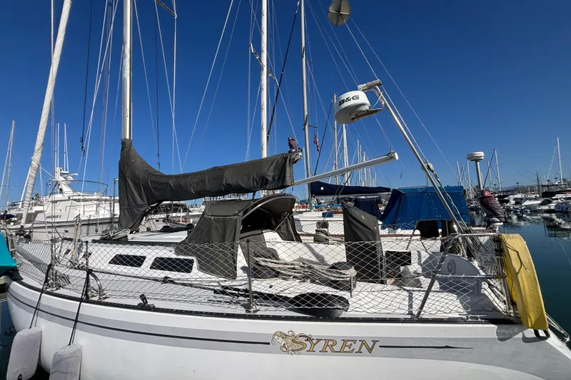 1979 Islander Peterson 40 sailboat docked in marina under clear blue sky.