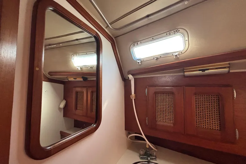 1979 Islander Peterson 40 yacht interior with wooden cabinets and mirror.