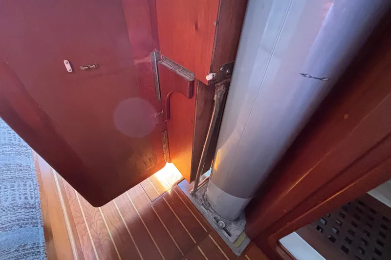 Interior view of 1979 Islander Peterson 40 sailboat, featuring wooden flooring and mast detail.