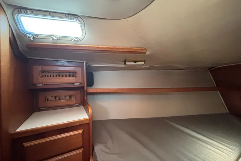 Interior cabin of 1979 Islander Peterson 40 sailboat with wooden storage and bed.