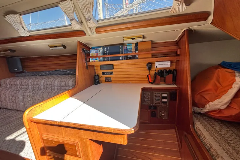 Interior of 1979 Islander Peterson 40 sailboat with navigation station and cozy sleeping area.