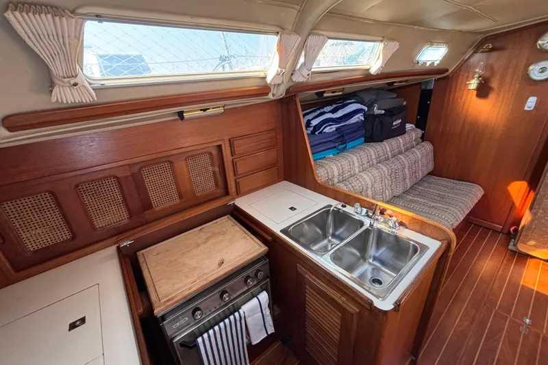 Interior of 1979 Islander Peterson 40 sailboat with wood finish, kitchenette, and seating area.