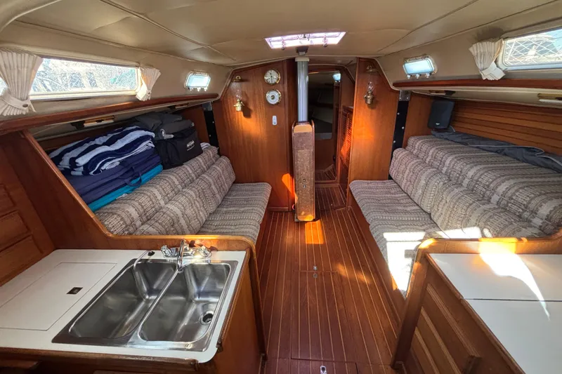 Interior of 1979 Islander Peterson 40 sailboat with wood paneling and cozy seating.