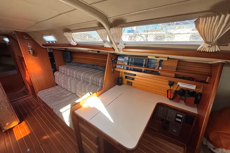 Interior of 1979 Islander Peterson 40 sailboat with cozy seating and navigation station.
