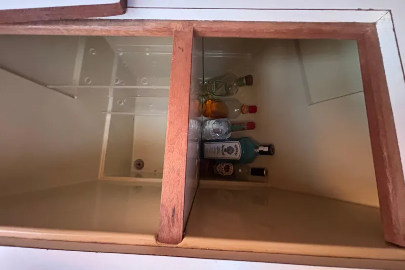 Storage compartment with assorted liquor bottles on a 1979 Islander Peterson 40 yacht.