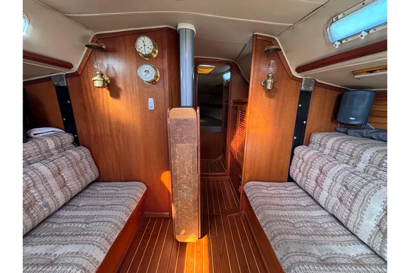 Interior of 1979 Islander Peterson 40 sailboat with wood paneling and cozy seating.