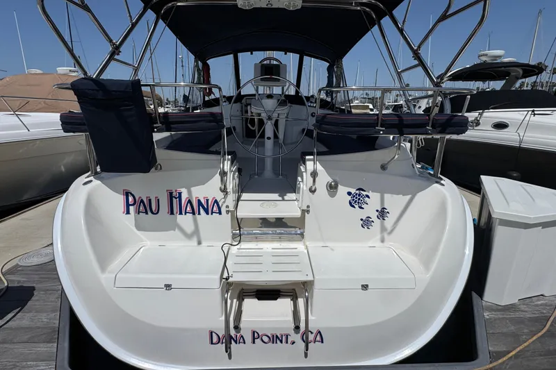 2004 Hunter 41 Aft Cockpit sailboat docked, featuring "Pau Hana" name and turtle decals.