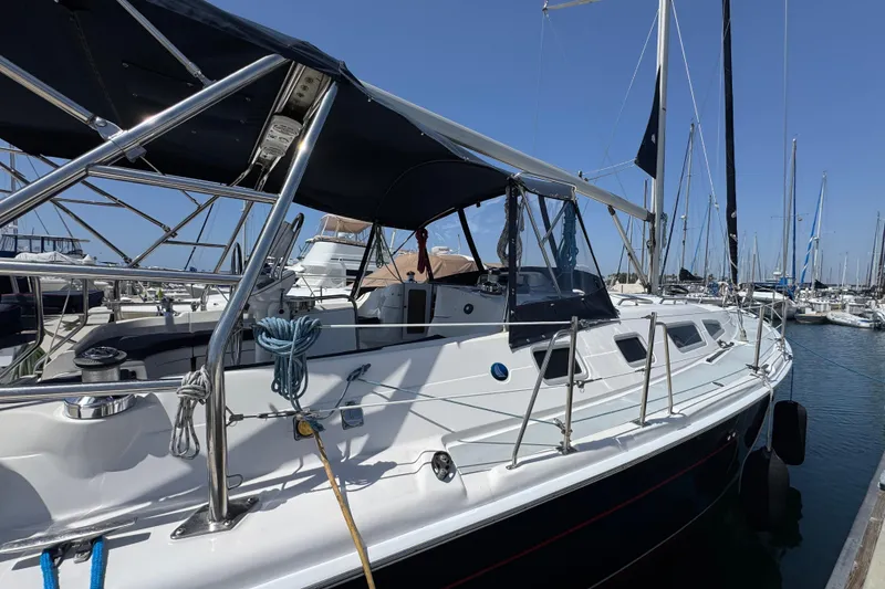 2004 Hunter 41 Aft Cockpit sailboat docked in a marina under clear blue skies.