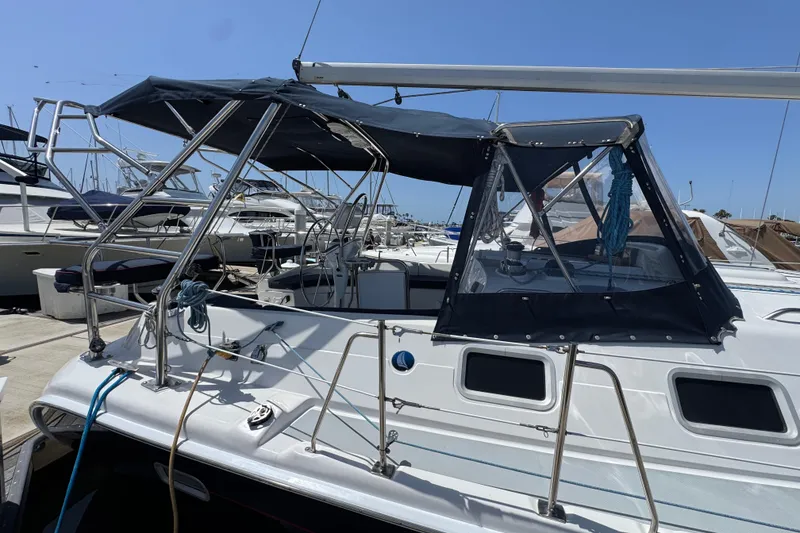 2004 Hunter 41 Aft Cockpit sailboat docked at marina under clear blue sky.