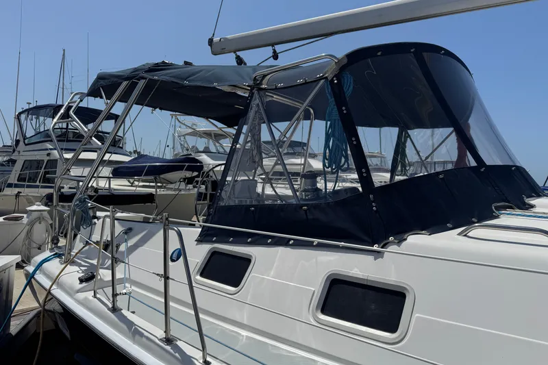 2004 Hunter 41 Aft Cockpit sailboat docked, featuring a sleek design and protective canopy.