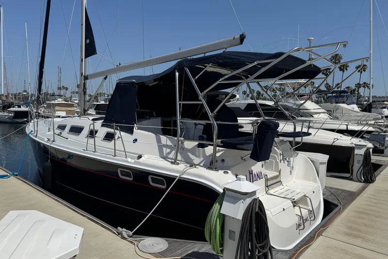 2004 Hunter 41 Aft Cockpit sailboat docked at marina under clear blue sky.
