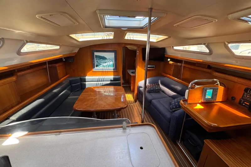 Luxurious interior of 2004 Hunter 41 Aft Cockpit sailboat with wood finishes and seating area.