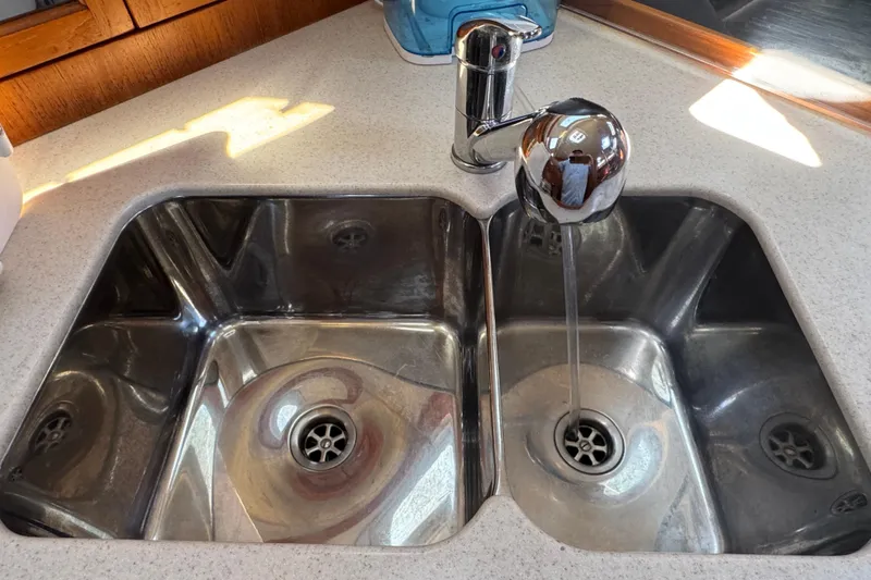 Stainless steel double sink with running water in a 2004 Hunter 41 Aft Cockpit yacht.