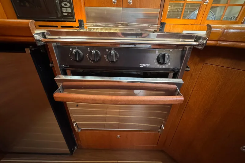 2004 Hunter 41 Aft Cockpit yacht kitchen with stainless steel oven and wooden cabinetry.