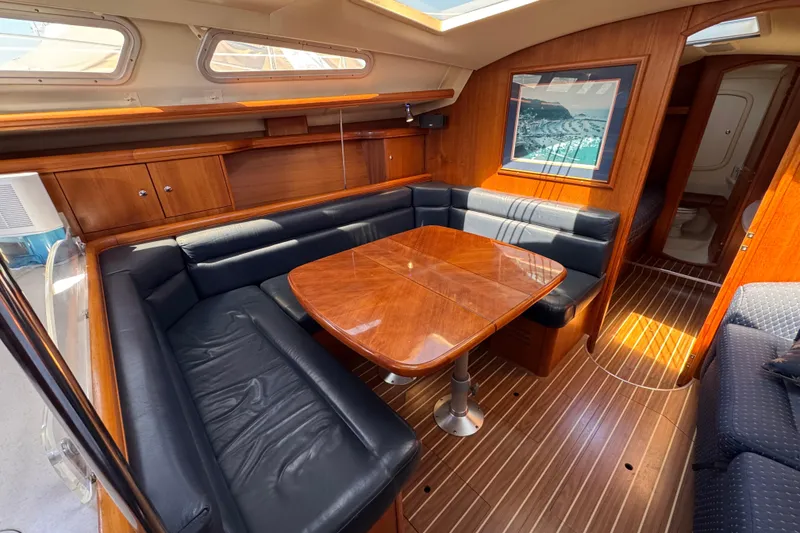 Luxurious interior of 2004 Hunter 41 Aft Cockpit yacht with wood finish and leather seating.