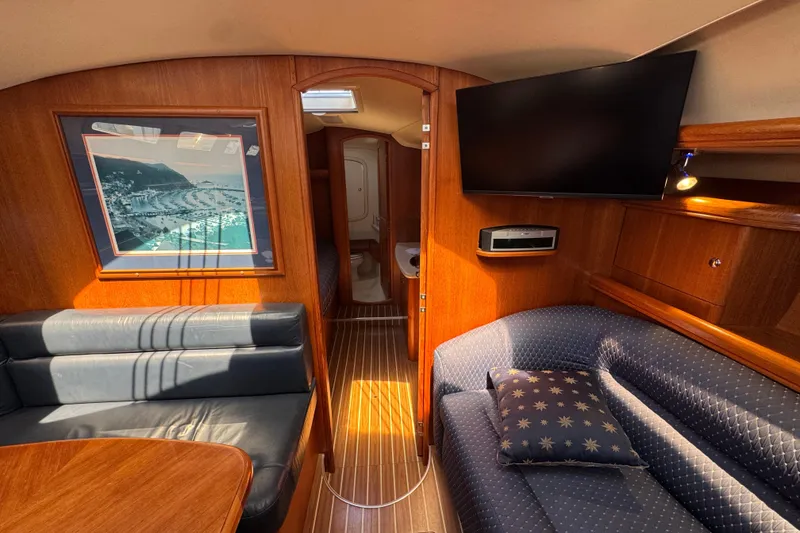 Interior of 2004 Hunter 41 Aft Cockpit yacht with cozy seating and wall art.
