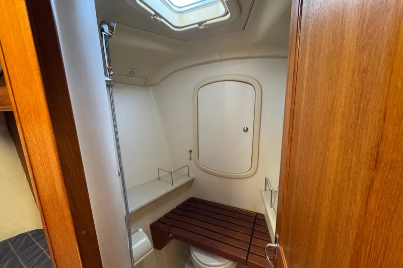 2004 Hunter 41 Aft Cockpit bathroom with wooden accents and overhead skylight.
