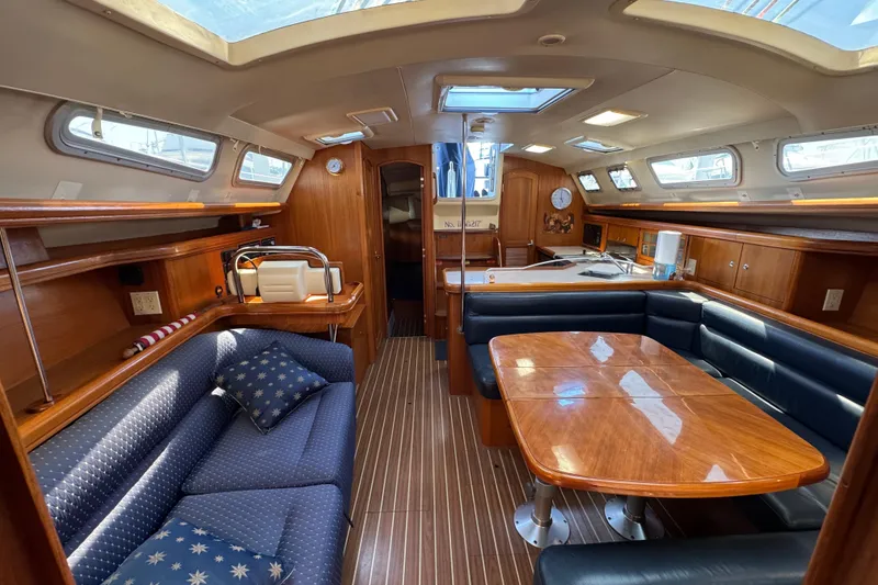 Interior of 2004 Hunter 41 Aft Cockpit sailboat with wood finish and seating area.