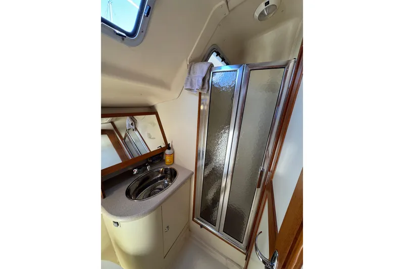 2004 Hunter 41 Aft Cockpit yacht bathroom with sink, mirror, and shower.