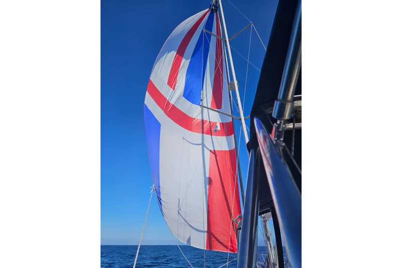 Sailing yacht with colorful spinnaker sail, Hunter 41 Aft Cockpit, 2004 model, on open sea.