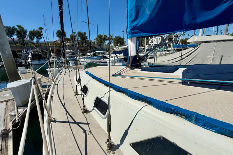 1988 Catalina 34 sailboat docked at marina with blue sail cover.