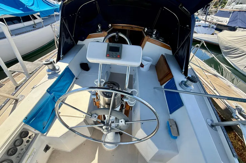 Cockpit of a 1988 Catalina 34 sailboat with steering wheel and navigation instruments.