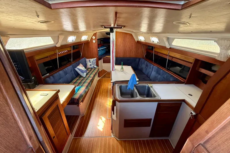 Interior of a 1988 Catalina 34 sailboat with cozy seating and wooden finishes.