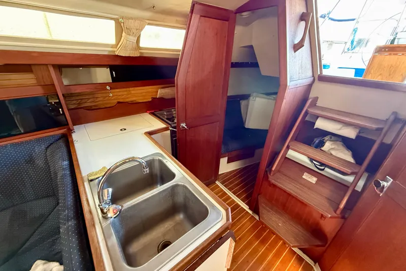 Interior of a 1988 Catalina 34 sailboat featuring a compact kitchen area.