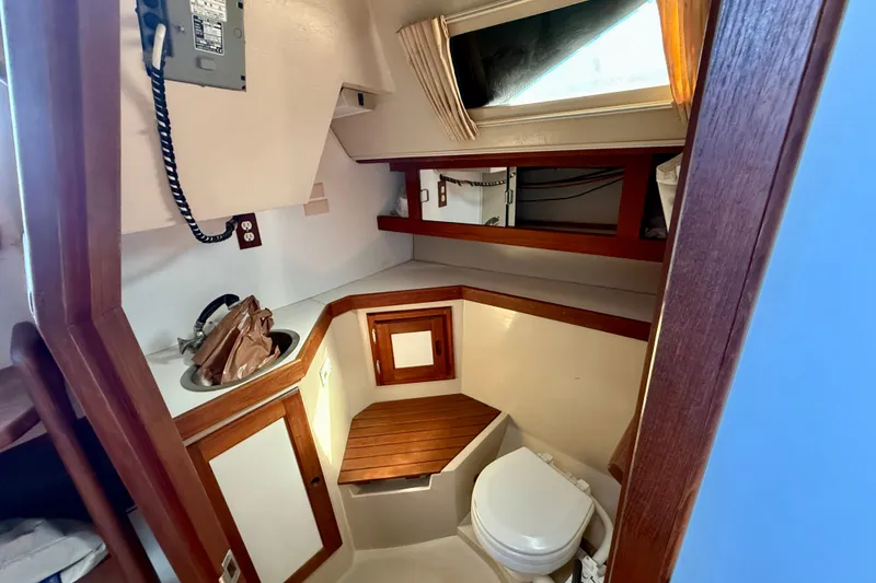 1988 Catalina 34 yacht bathroom with wooden accents, sink, and toilet.