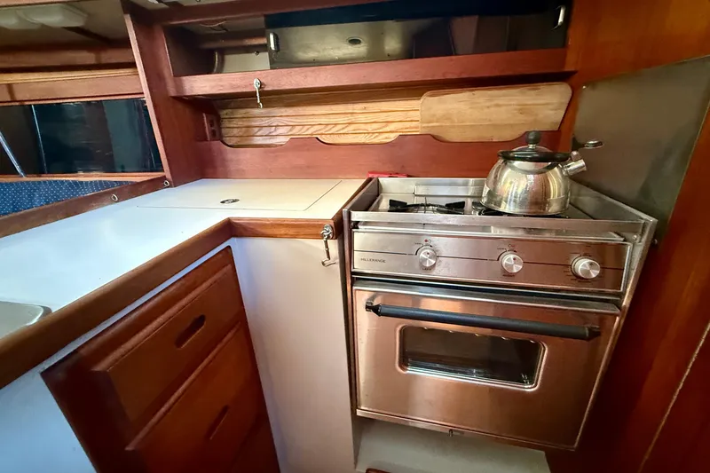 Galley kitchen in 1988 Catalina 34 sailboat with stove and kettle.