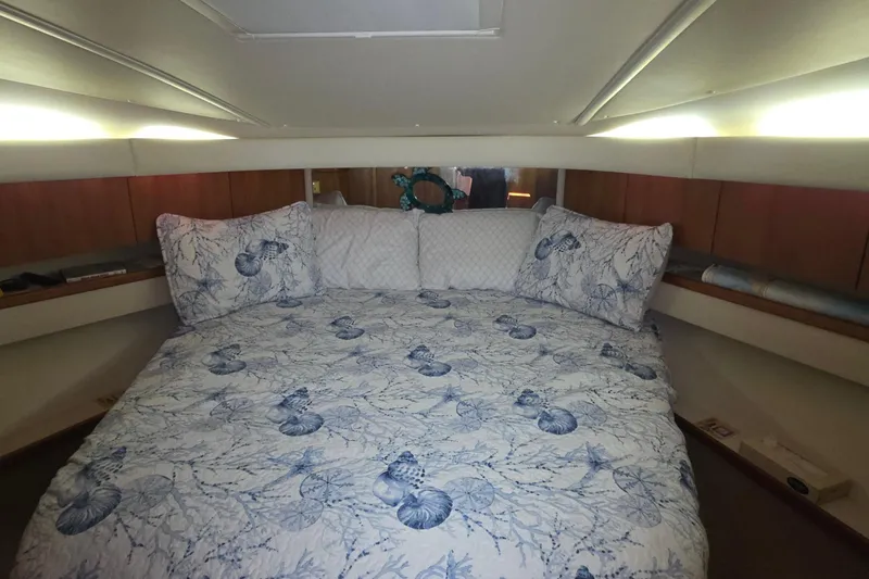 Luxurious cabin interior of 2004 Tiara Yachts 4000 Express with nautical-themed bedding.