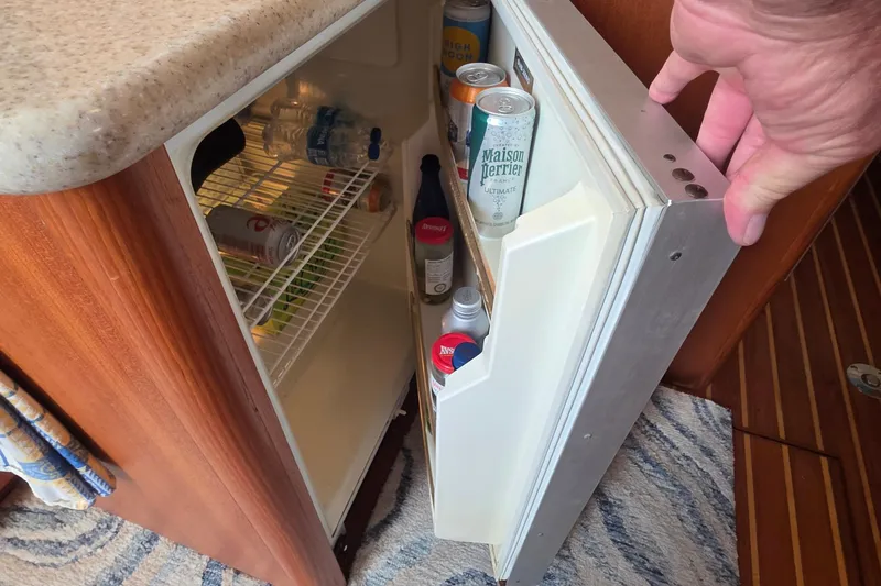 Mini fridge stocked with beverages on a 2004 Tiara Yachts 4000 Express boat.
