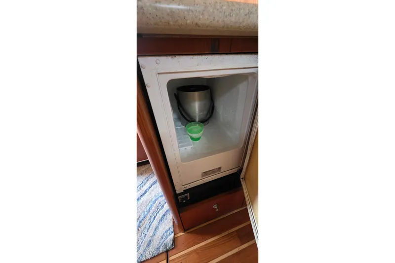 Small refrigerator inside 2004 Tiara Yachts 4000 Express, containing a green cup and a pot.