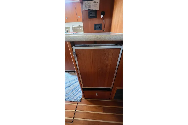 2004 Tiara Yachts 4000 Express interior with wooden cabinetry and compact refrigerator.