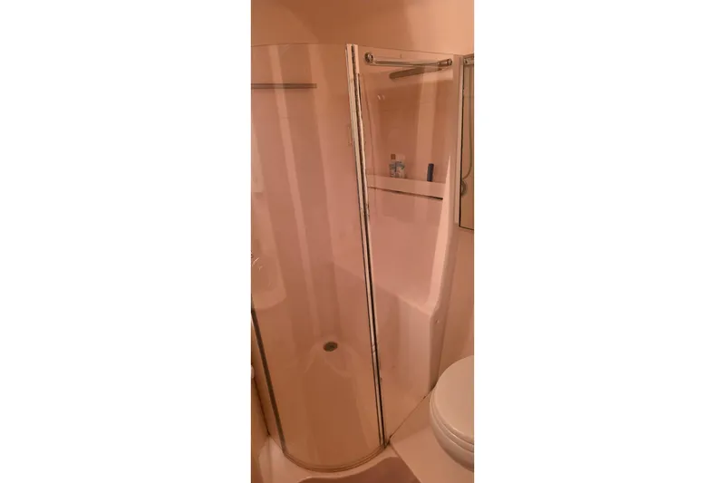 Shower area in 2004 Tiara Yachts 4000 Express, featuring glass door and shelf.