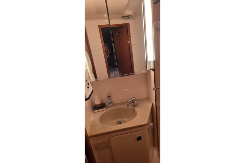 Bathroom vanity in 2004 Tiara Yachts 4000 Express, featuring a sink and mirror.