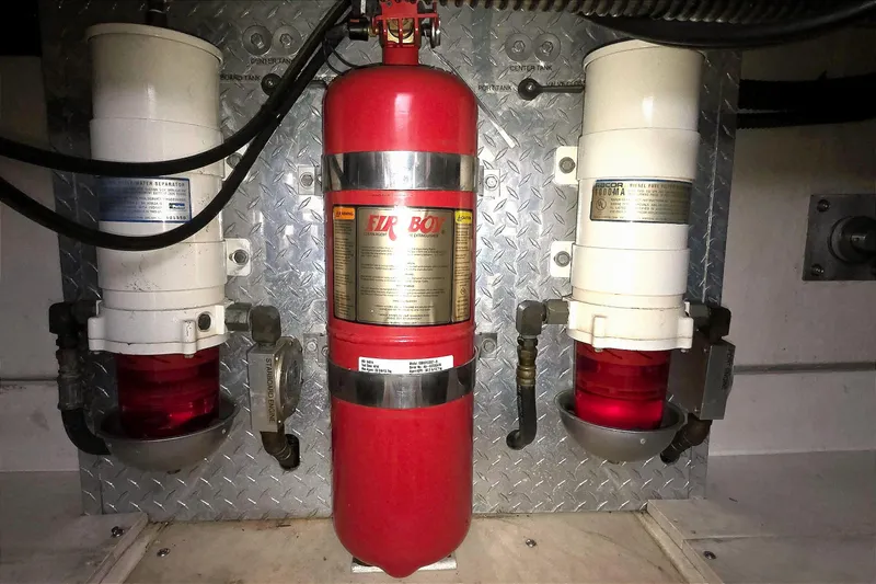 Engine room of 2004 Tiara Yachts 4000 Express with fire extinguisher and fuel filters.